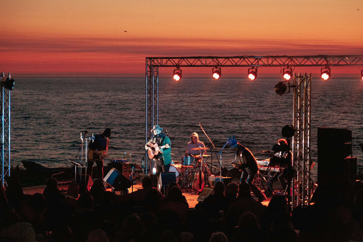Musiciens sur la scène lors d'un spectacle au coucher de soleil