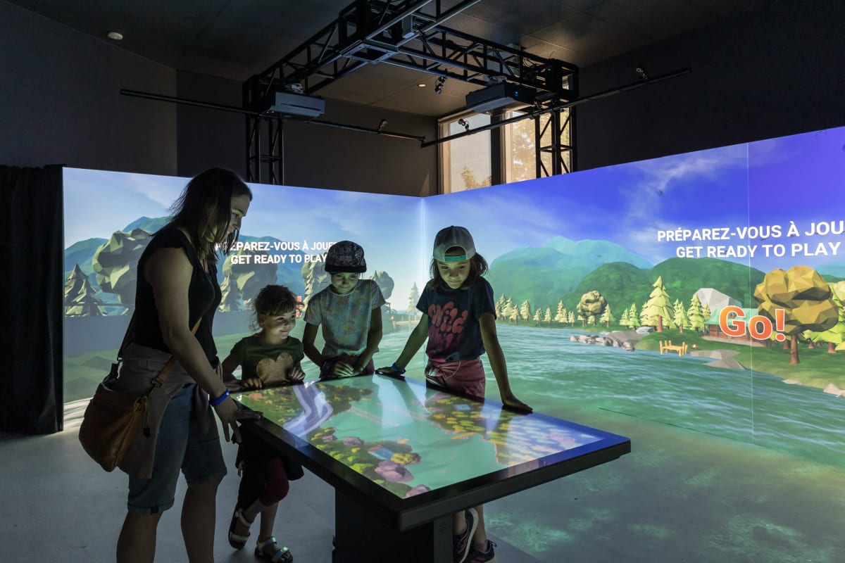 4 enfants autour d'une console interactive à l'exposition Acoatica.