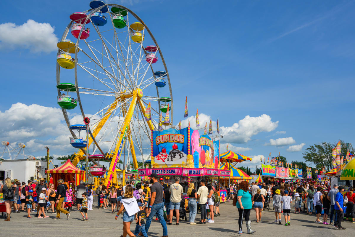 Manèges et kiosques colorés avec une foule de personne à l'Expo agricole de Saint-Hyacinthe.