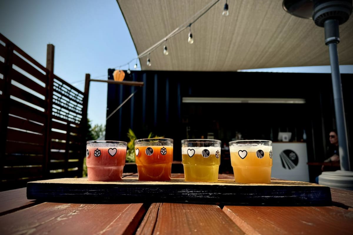 Plateau de dégustation de 4 bières posé sur une table extérieure à la microbrasserie Perspective.