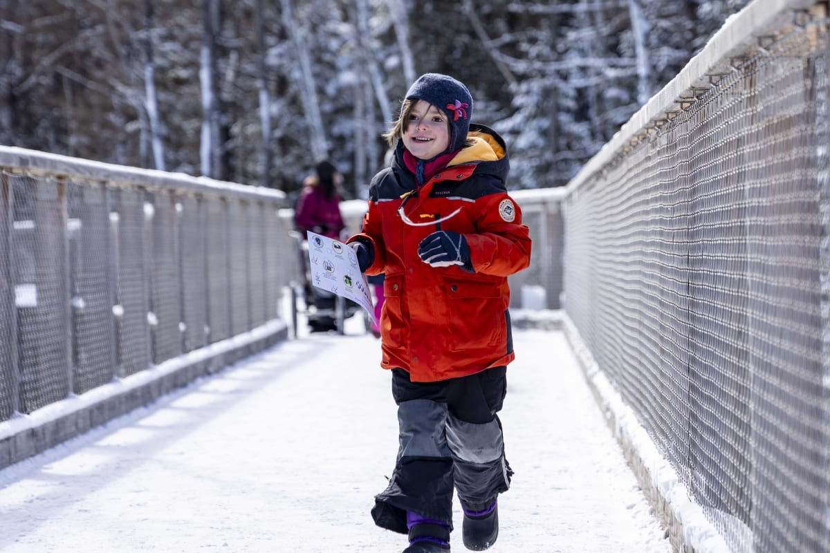 Enfant faisant un quiz au Sentier des cimes. 