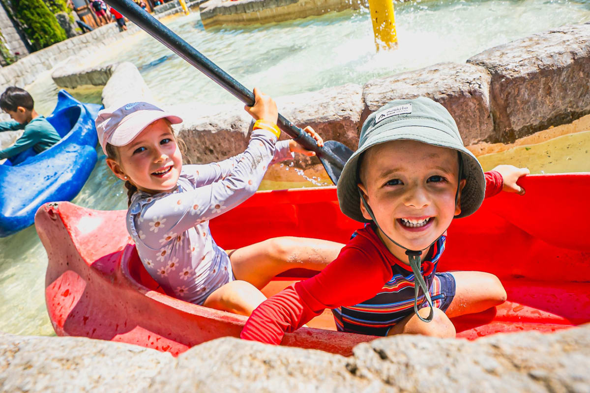 Deux jeunes enfants dans un petit kayak dans un circuit d'eau calme