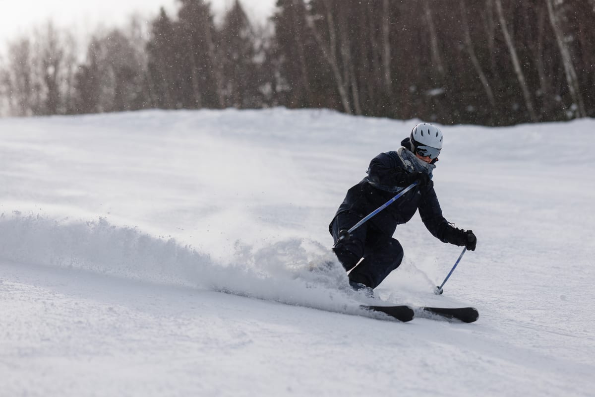 Personne en descente rapide sur une piste de ski alpin.