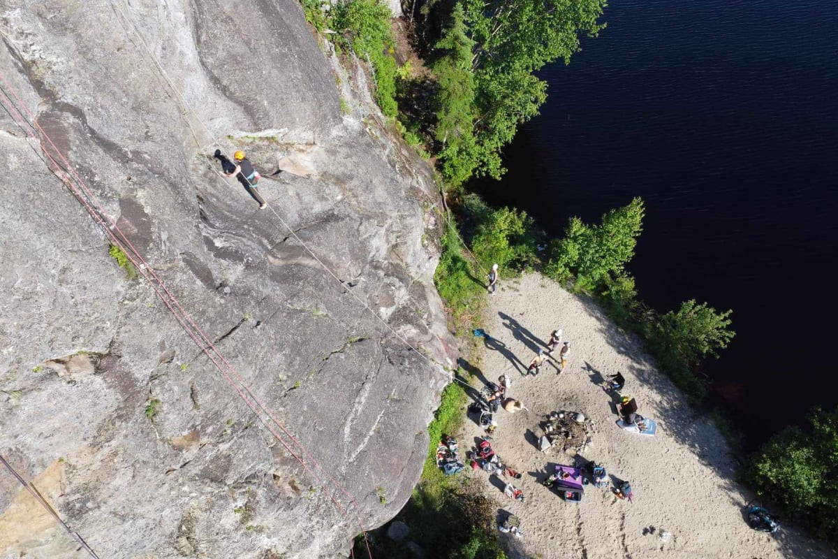 Vue en plongée d'un groupe de grimpeurs au pas d'une paroi d'escalade