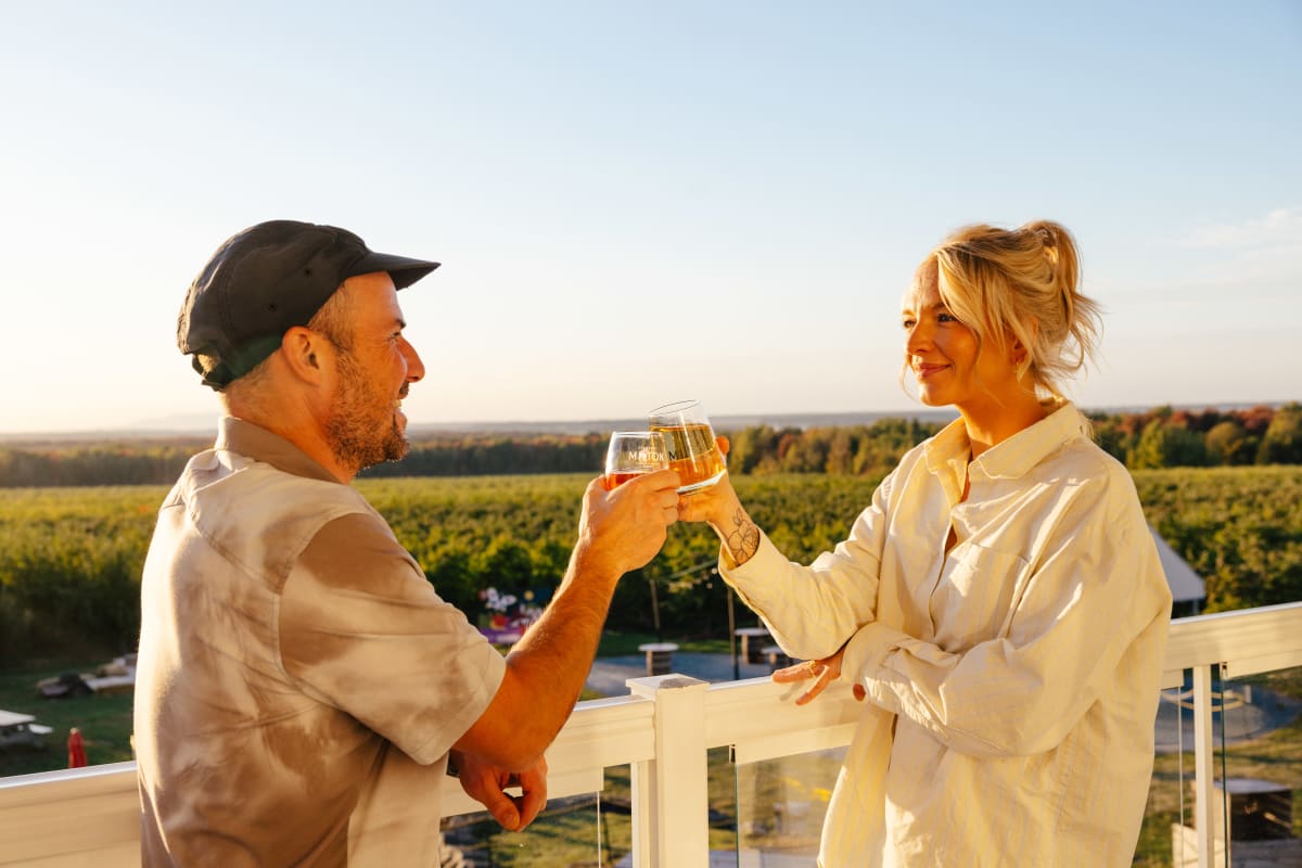 A man and a woman are having a drink on a patio.