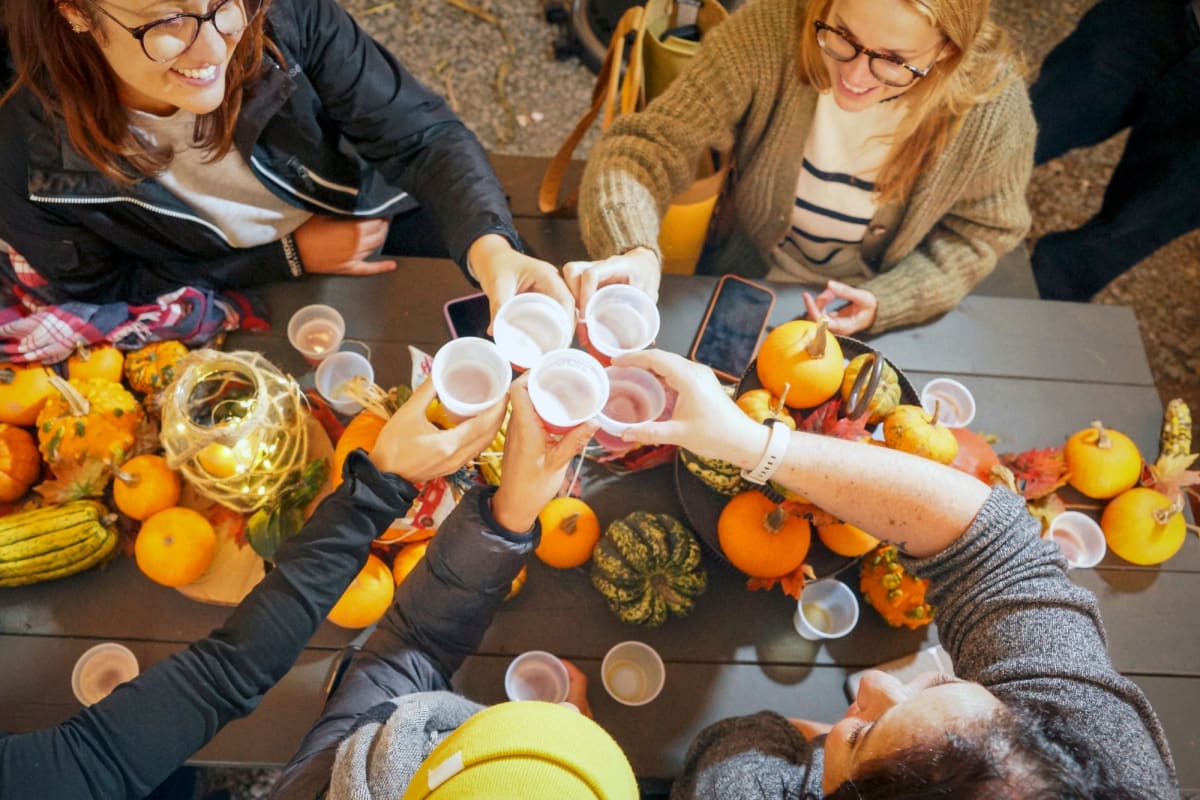 Groupe de femmes autour d'une table décorée de courges.