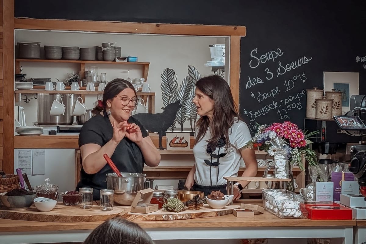 Deux femmes debout derrière un îlot dans une pâtisserie.