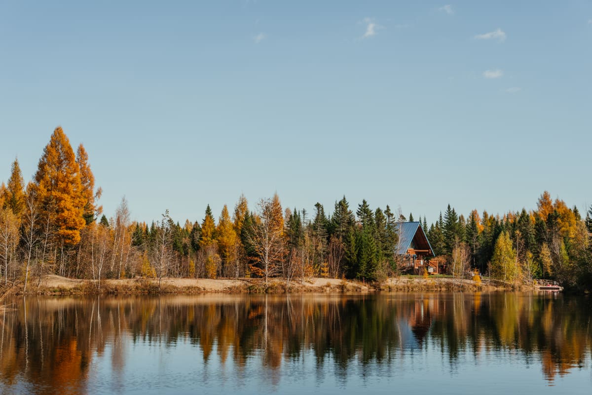 Chalet au bord d'un lac en automne Au Chalet en bois rond.