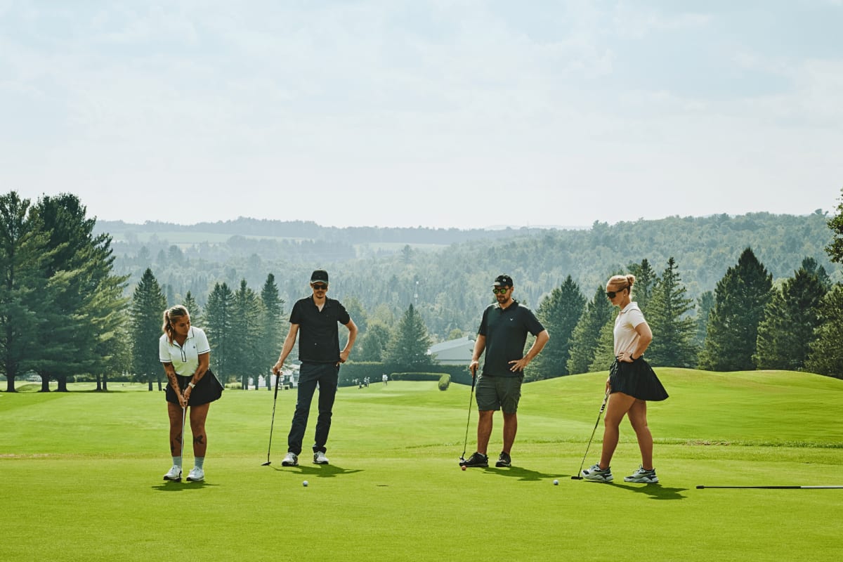 Four people on a green at the Milby Golf Club.