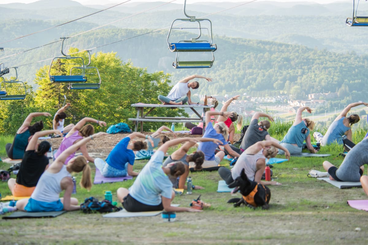 Groupe de personnes faisant du yoga sur une montagne