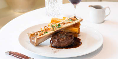 Assiette gastronomique avec filet de bœuf, os à moelle et sauce brune.