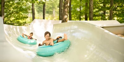 Children on tubes in a water slide.