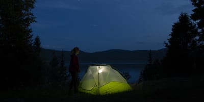 Tente verte illuminée la nuit au Camping du parc national du Fjord-du-Saguenay.