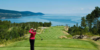 Man seen from behind playing golf at the Fairmont Le Manoir Richelieu Golf Club.