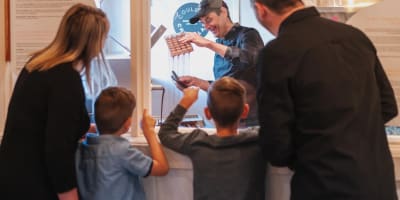 Famille observant un chocolatier à l'oeuvre.