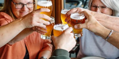Des gens autour d'une table avec une pizza et de la bière de Des Cantons Microbrasserie.