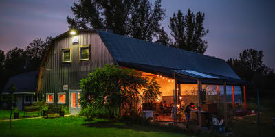 Domaine Ives Hill - Une bâtisse avec une terrasse illuminée en soirée