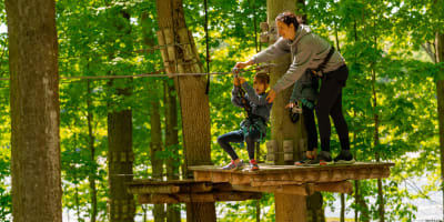 Mère et fille qui font un parcours dans les arbres à Extéria