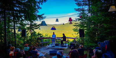 Concert au belvédère : public assis, abat-jours et vue sur la vallée