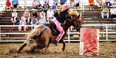 Femme faisant une course de barils au Festival Western de Guigues.