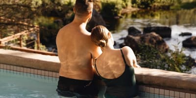 Un couple se détend dans une piscine extérieur en pleine nature.