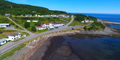 Aerial view of the Hôtel Motel Grande-Vallée on the waterfront.