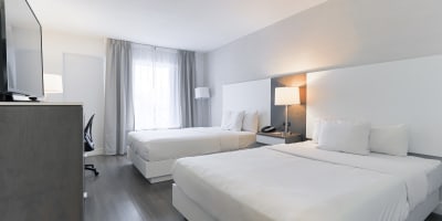 Une chambre avec deux lits doubles à l'Hôtel Universel Québec.