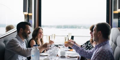 Hôtel Verso - Quatre adultes assis autour d'une table dans un restaurant avec vue sur l'eau.