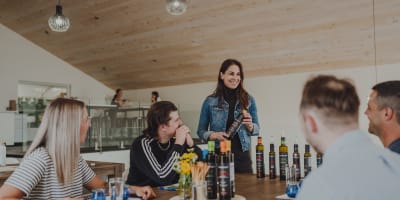 Une femme présente des huiles à l'Huilerie TournevenT.