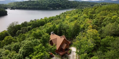 Aerial view of a cabin near a lake in summer.