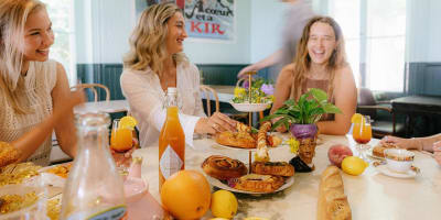 La Midinette - Women sitting at a table filled with pastries and fruit