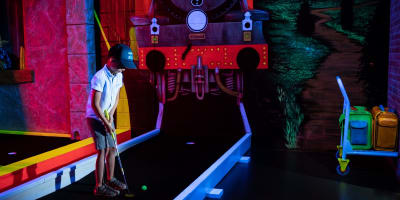 Children are playing a game of mini-golf at Laser Force Drummondville