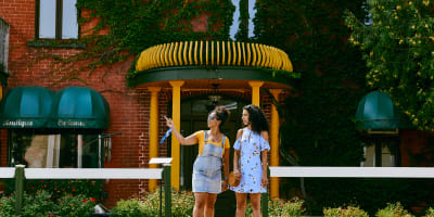 The artists and artisans of Montebello - Two individuals are standing on a sidewalk, looking in the same direction.