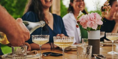 Les Cocagnes - Femmes souriantes assises à une table à l'extérieure