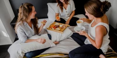 Three women having breakfast in bed