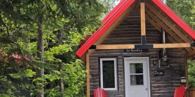 Micro-Chalets des Appalaches - Petit chalet avec deux chaises rouges sur le balcon