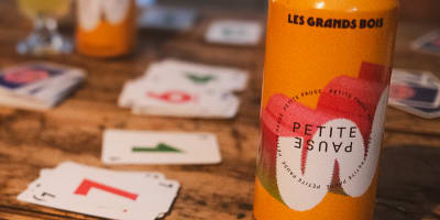 Microbrasserie Les Grands Bois - A bottle and cards on a wooden table