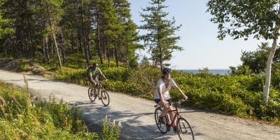 Parc national de la Pointe-Taillon - Un homme et une femme font du vélo en nature