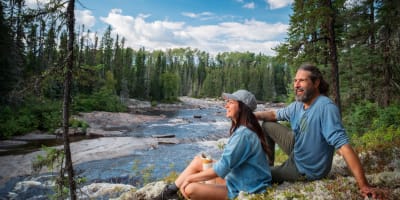Homme et femme assis sur le bord de la rivière en été. 