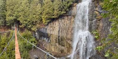 Pont flottant devant des chutes: Parcours Aventures - Via ferrata Gaspésie.