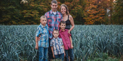 The Therrien family of Potager Therrien in a field at dusk.