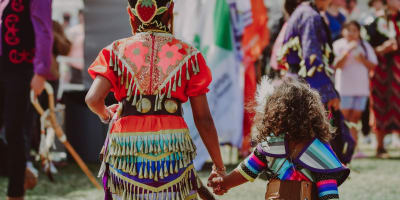 Two young Native girls adorned in their regalia at the powwow.