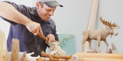 Wood sculptor and wooden moose.