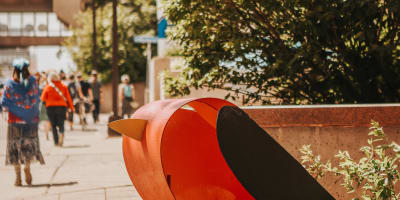 Sculpture en oiseau sur un trottoir. 