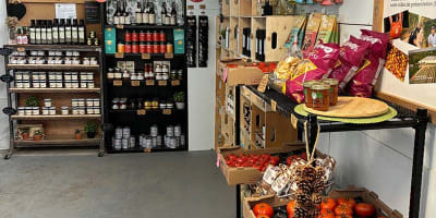Kiosque intérieur avec produits et tomates en vente. 