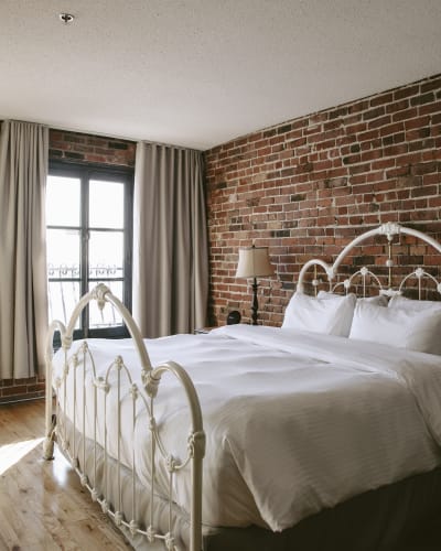 Auberge du Vieux-Port - Chambre avec un mur de briques