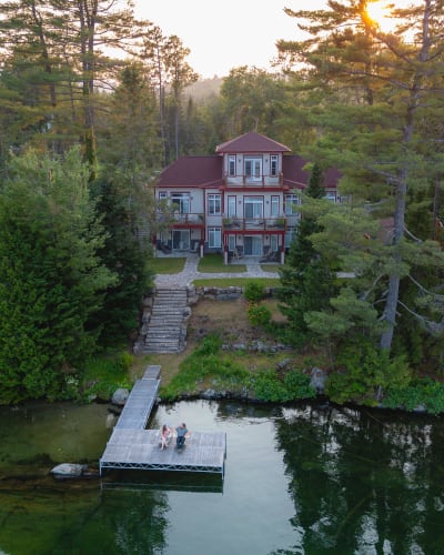 Vue aérienne de l'auberge et du lac en soirée l'été.
