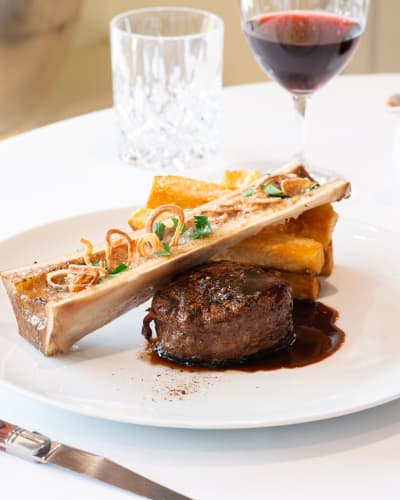 Assiette gastronomique avec filet de bœuf, os à moelle et sauce brune.
