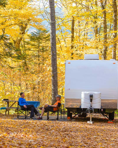Deux personnes assises à côté d'un VR au Parc national de la Jacques-Cartier, en automne.
