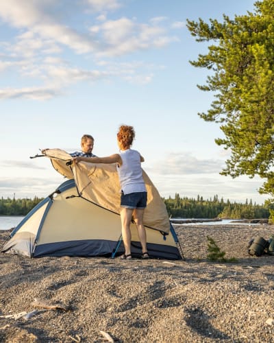 Un couple installe une tente au parc national de la Pointe-Taillon.